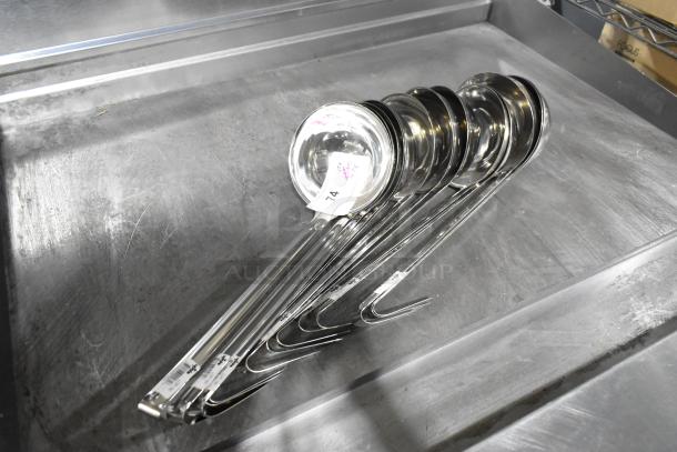 Set of 23 Update LOP-1813 stainless steel ladles, brand new with minor scratches. Auction tags visible on handles.