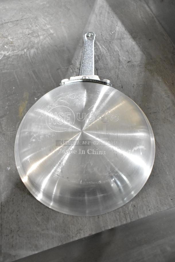 Brand new Update fry pan with visible NSF marking and "Made in China" label. Slight scratches present. Model AFP-07.