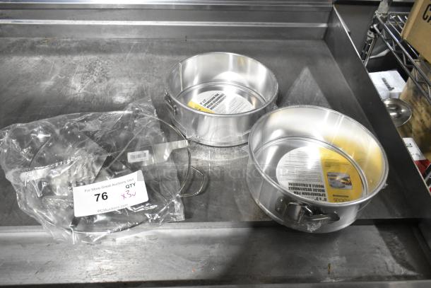 Three brand new scratch and dent items: 2 springform baking pans with labels, 1 pie cutter in packaging. Auction lot 76.