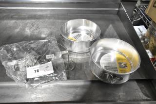 Three brand new scratch and dent items: 2 springform baking pans with labels, 1 pie cutter in packaging. Auction lot 76.