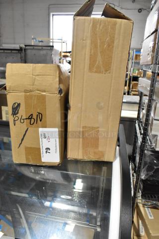 Two sealed boxes containing a new Update TD-MFOLD Surface Mount Paper Towel Dispenser and an Update PG810 Wire Pan Grate.