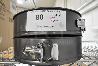 2 new Update CPSF-10 springform pans, 10-inch metal, secure latch, label indicates QTY 2, auction item 80.