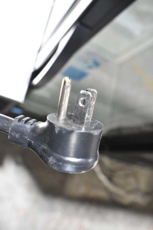Close-up of the plug from a 2025 True GDM-12-HC commercial cooler merchandiser, showing a standard 115V connector.