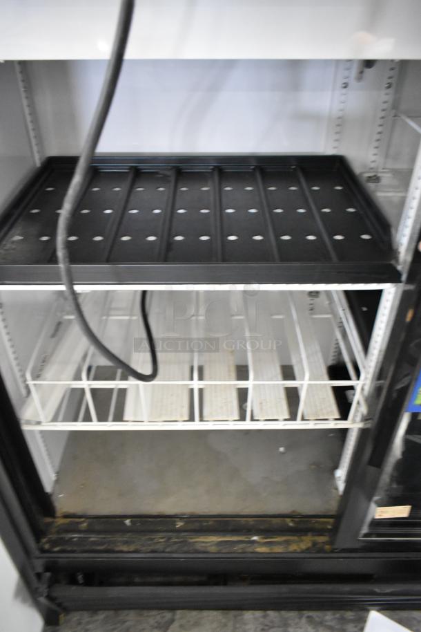 2017 True GDM-41SL-48-HC-LD metal cooler merchandiser with poly coated racks. Two-door reach-in style; interior shows light wear.