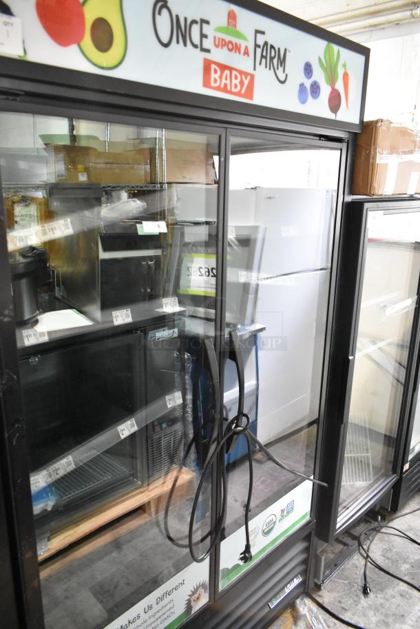True TVM-48SL-HC 2 Door Reach-In Cooler Merchandiser, metal racks, 115V, 1 Phase, branded "Once Upon a Farm", good condition.