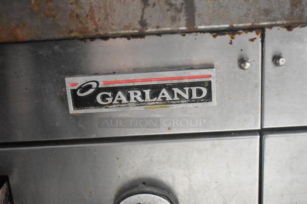 Garland stainless steel electric griddle, countertop model, showing brand logo. Features durable build. Signs of use visible.