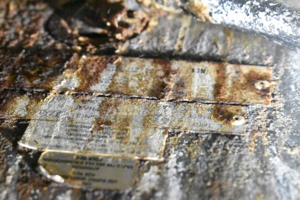 Rusty metal labels on Garland griddle indicate make and model; visible corrosion and wear present.