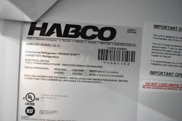 Label on 2019 Habco SE18 commercial cooler showing model, electrical rating, refrigerant type, and certifications. Door needs fixing.