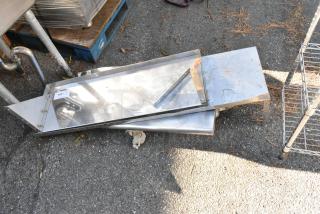 3 metal wall mount shelves on ground, used condition, rust spots visible. Attached label reads "163".