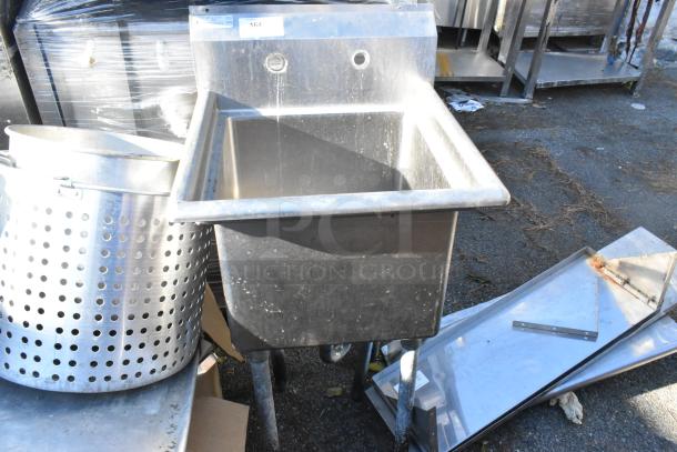 Stainless steel commercial single bay sink, sturdy design, used condition, visible mounting holes and wear marks.