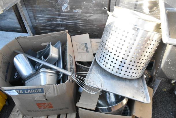 Pallet lot with metal stock pot, stainless drop-in bins, baking pan, whisk, and metal scoop; used condition in boxes.