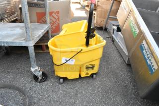 Rubbermaid yellow poly mop bucket with wringing attachment, features WaveBrake technology, in good condition with visible logo.