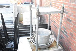 5 Stainless steel table with metal under shelf, Carlisle black poly insulated food carrier, metal bowls; outdoor setting.