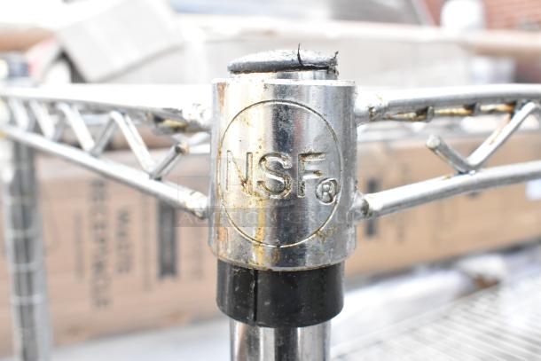 Chrome finish 3-tier wire shelving unit with NSF certification mark visible, slight wear on metal surface.