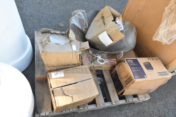 Boxes on a pallet containing brand new items, including Vitamix boxes, fragile labels, and a Tork paper towel dispenser.