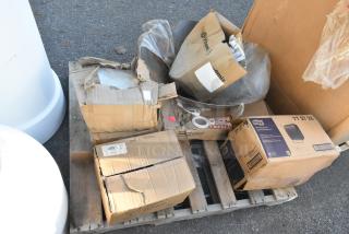 Boxes on a pallet containing brand new items, including Vitamix boxes, fragile labels, and a Tork paper towel dispenser.