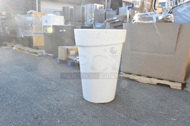 White poly trash can, cylindrical shape, outdoor setting. Appears in good condition, near new, suitable for various uses.