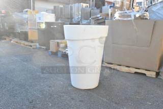 White poly trash can, cylindrical shape, outdoor setting. Appears in good condition, near new, suitable for various uses.