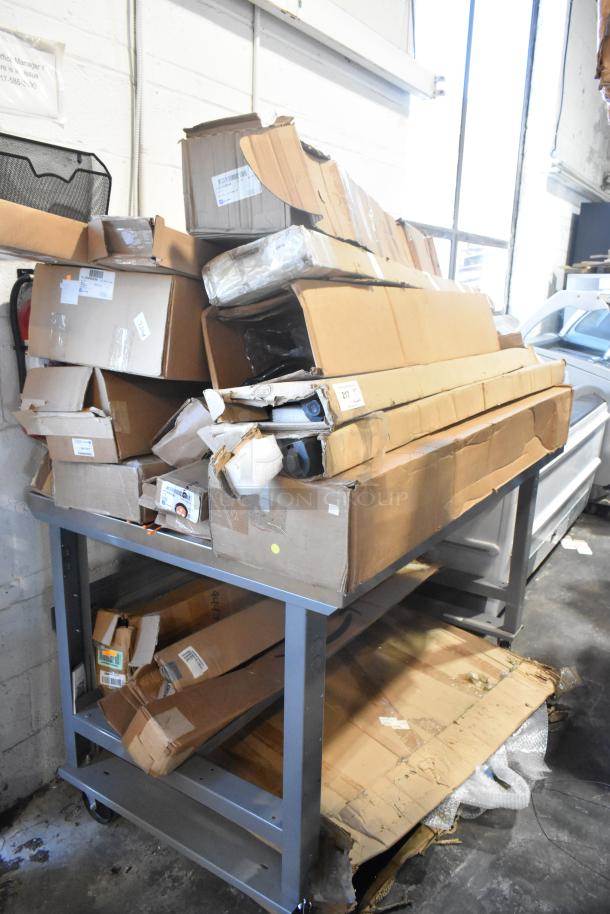 Table with 12 brand new items in boxes, including GM22936585 Cargo Area Security Enclosure, GM23256564 Roof Luggage Rail.