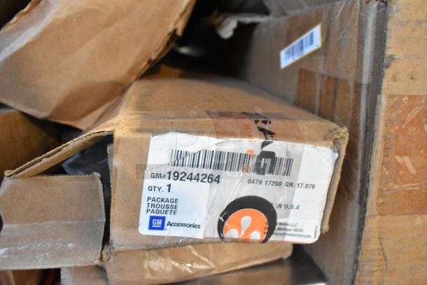 Table lot of 12 new GM auto parts in boxes; includes GM 19244264, 22936585, 23256564. Labels show GM Accessories branding.