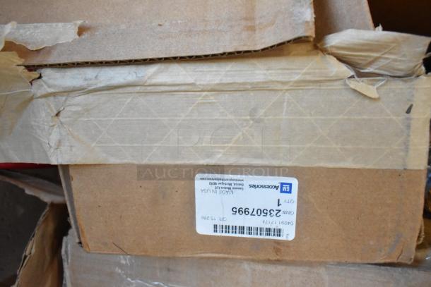 Table lot of 12 brand new GM items including GM22936585 security enclosure, GM23256564 luggage rail, GM23499.99 grille, GM19244264 roof rail. Box label shows GM part 23507995.
