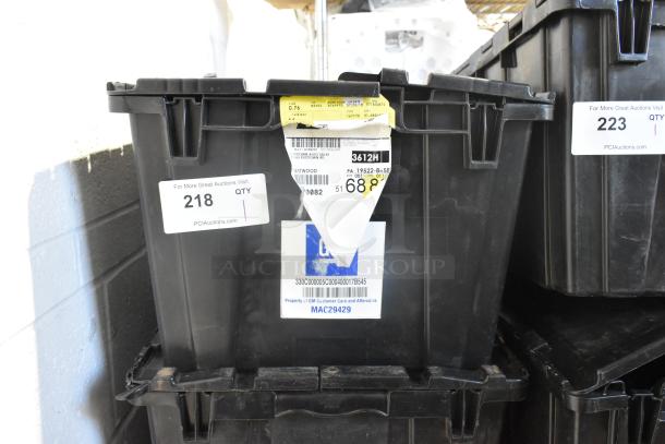 Black poly bin labeled with auction tags, containing a brand new lot of various car mats.