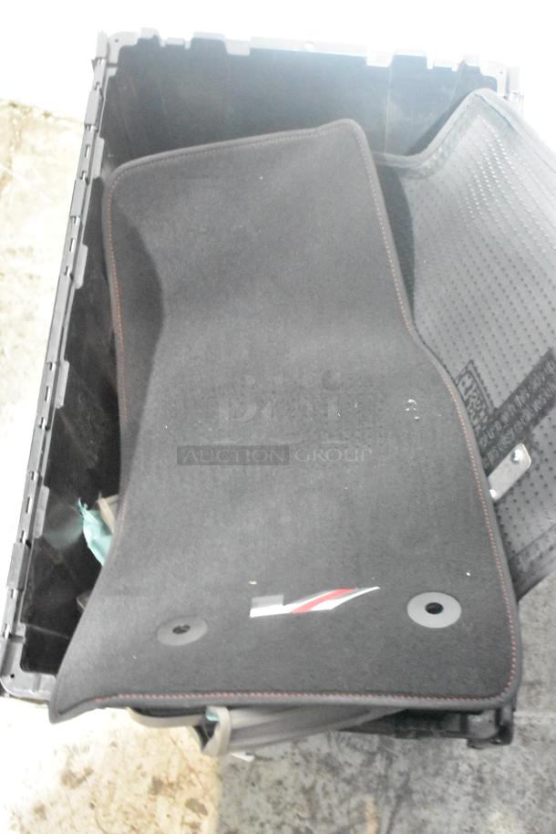 Black car mats with logo in a poly bin, brand new condition, features textured backing for grip.