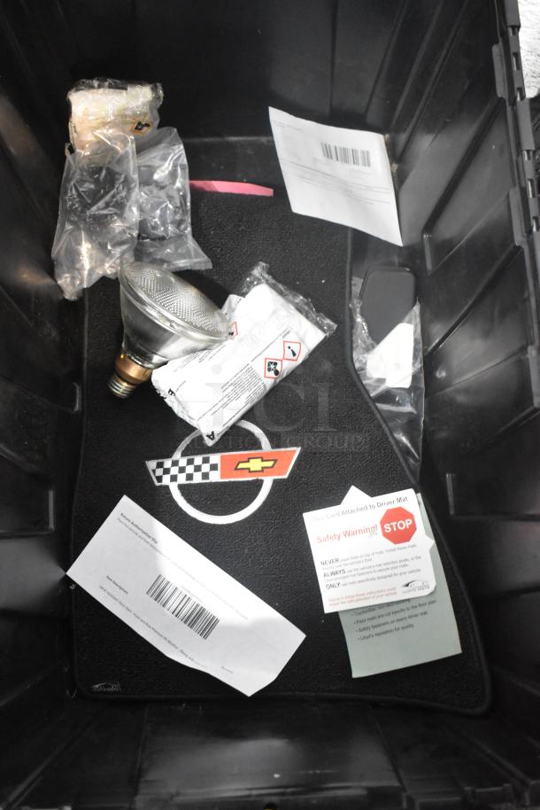 Brand new car mats with Chevrolet logo in black poly bin, includes safety warning tags and packaging materials.