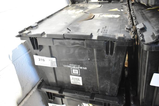 Black poly bin with Chevy emblems and various car parts, labeled "Property of Customer Care & Aftersales, GM."