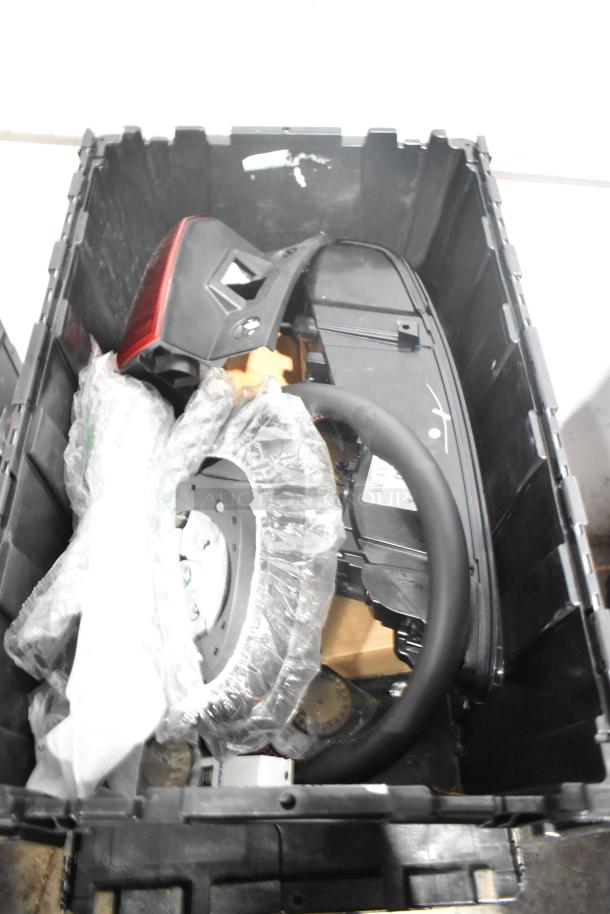 Brand new lot of car parts in black poly bin, includes brake light and Cadillac valve stem caps.