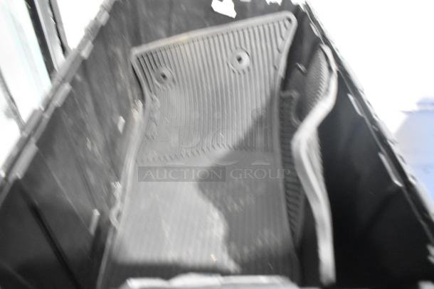 Black poly bin containing brand new black car mats and various car parts, organized neatly.