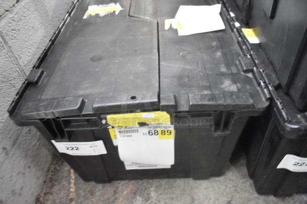 Black poly bin containing a lot of brand new car parts, including car mats. Labels indicate pricing and item details.