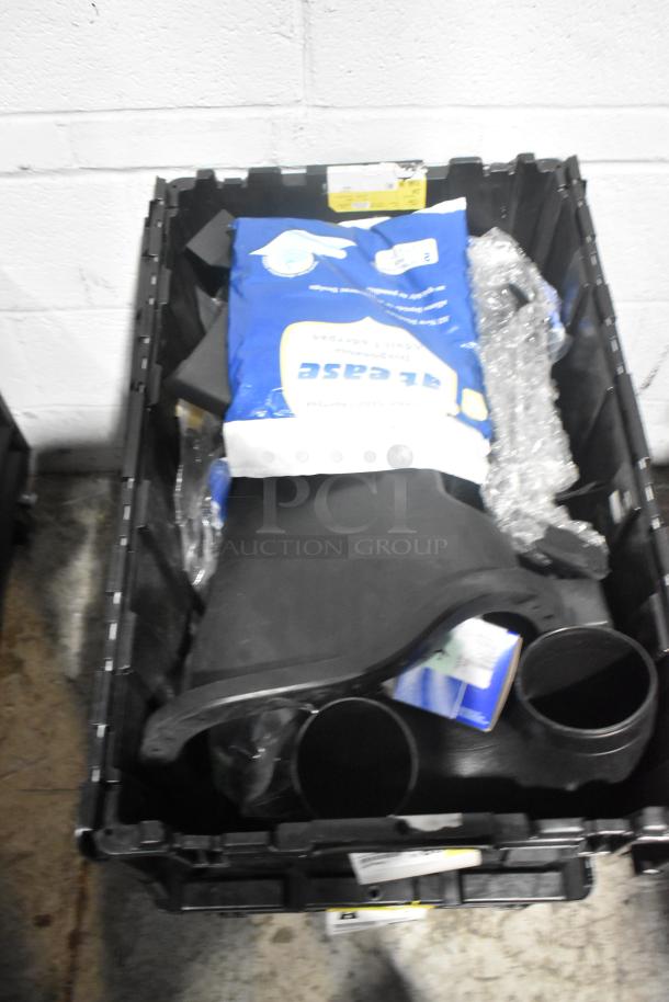 Brand new lot of assorted car parts in black poly bin, includes panels and various components.