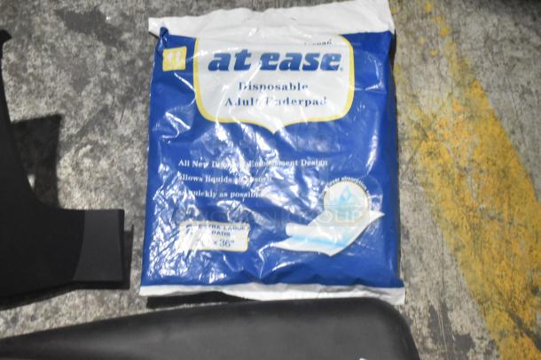 Brand new car parts in black poly bin, includes panels. The image also shows a package of disposable adult underpads labeled "at ease."