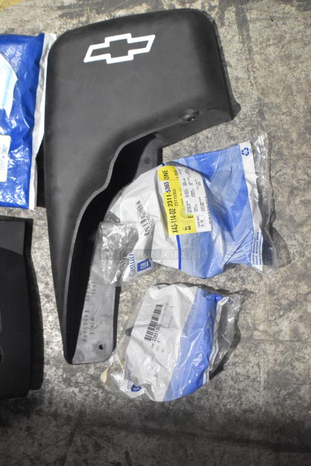 Brand new car parts lot, includes black panel with Chevrolet logo, genuine GM packaging and part labels visible.