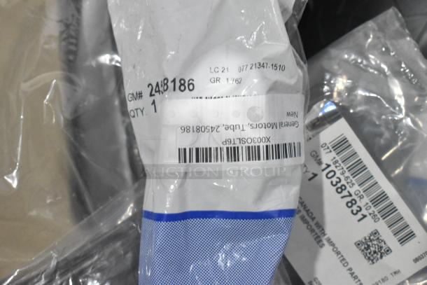Lot of new car parts in black poly bin, includes GM 84221510 ENS Filet and GM 25790357 ACDelco Brake Air Duct. Labels visible.