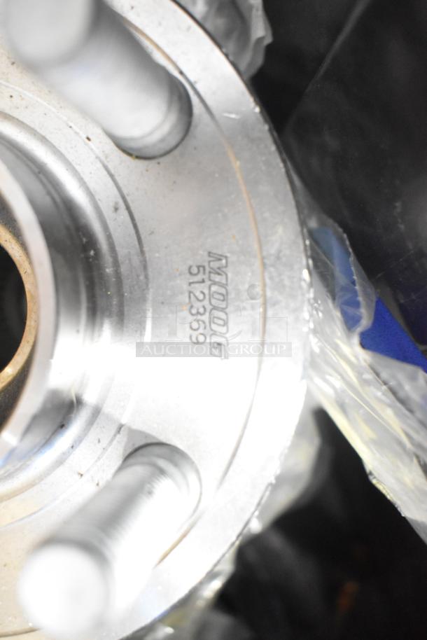 Close-up of Moog car part model 512369. Item is part of a brand new lot including GM grille, lug nuts, and cargo net.