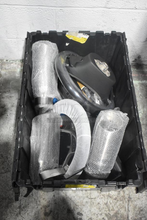 Brand new car parts including Corvette steering wheels in a black poly bin, wrapped in protective packaging. Tags visible.