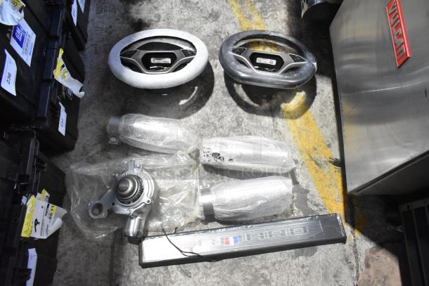 Brand new Corvette steering wheels and various car parts in black poly bin with visible GM labels and packaging.