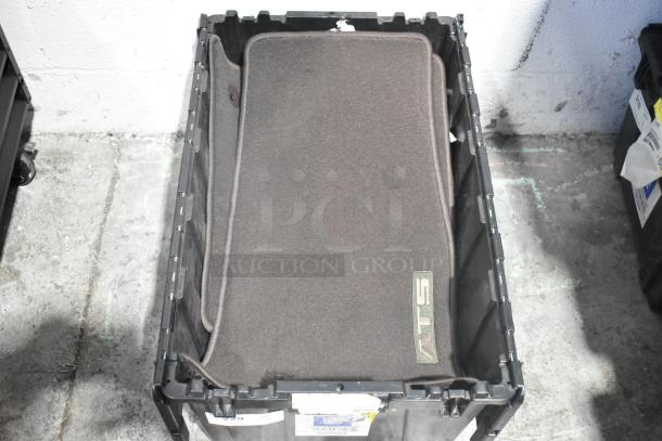 Lot of new car parts including car mats and Hawk Racing brake pads in a black poly bin, carpeted mats marked "ATS."