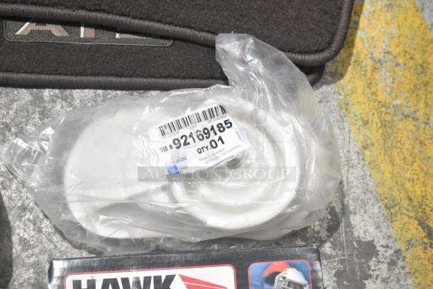 Brand new lot of car parts including car mats and Hawk Racing disc brake pads in a black poly bin, labeled "GM 92169185".