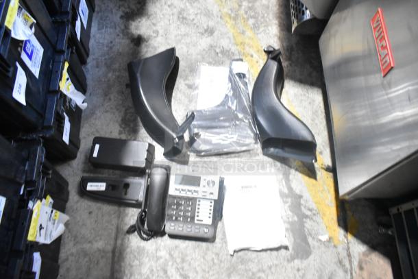 Lot of brand new car parts including telephone, black panels in a poly bin, with visible labels and tags.