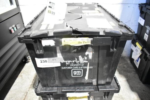 Black poly bin labeled "Property of Customer Care & Aftersales GM" containing brand new car parts and a telephone, lot no. 230.