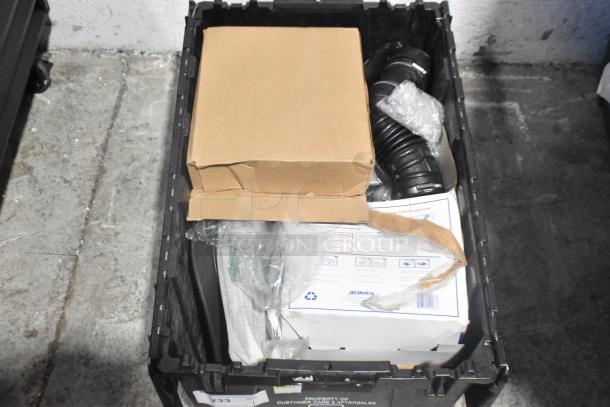 Brand new car parts including spark plugs in black poly bin; cardboard boxes and plastic wrap visible.