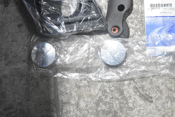 Brand new lot of car parts, including spark plugs in a black poly bin. Features GMC metal caps. Labels show "GM 22830718".