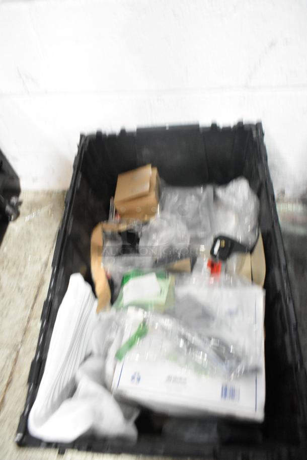 Brand new car parts in black poly bin; includes spark plugs, various components in packaging, pristine condition.