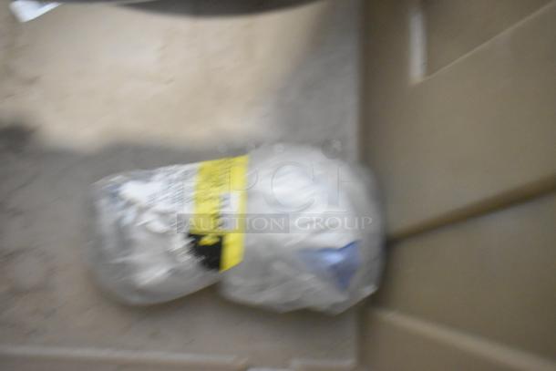 Brand new car parts including car mats in a tan poly bin; visible wrapped item with label.