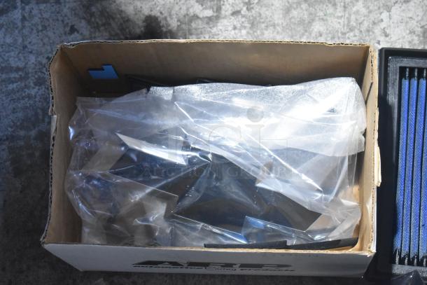 Brand new lot of car parts in cardboard box including GMC emblems, GM wheel locks wrapped in plastic, in black poly bin.