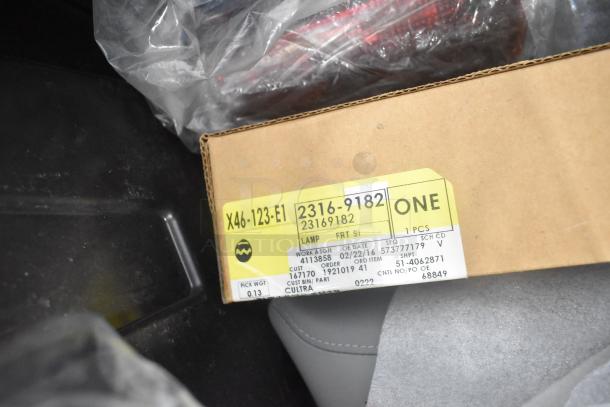 Brand new car parts in black poly bin, includes GMC emblems, GM wheel locks. Box labeled X46-123-E1, 2316-9182, lamp part.