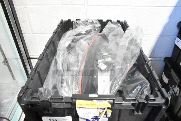 Brand new car parts including mats in a black poly bin, wrapped in plastic. Labels visible, indicating lot and item details.